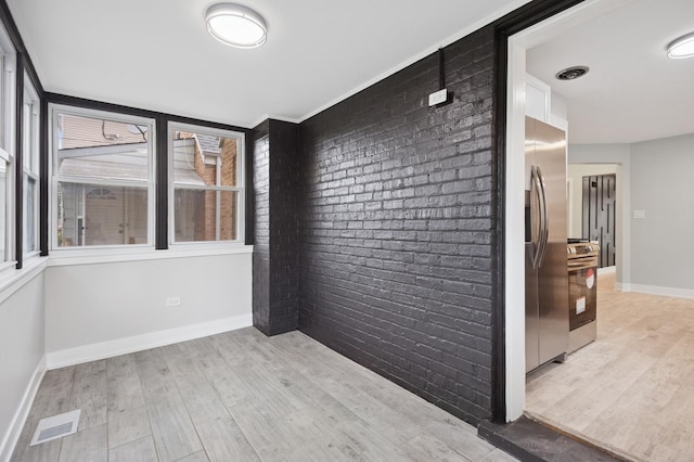 5406 N Mulligan Ave, Chicago, IL 60630 - spare room featuring light wood finished floors and brick wall