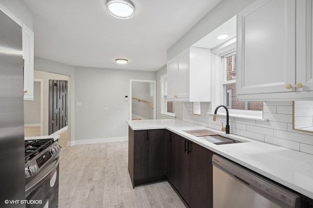 5406 N Mulligan Ave, Chicago, IL 60630 - kitchen with appliances with stainless steel finishes, white cabinets, backsplash, light countertops, and light wood-type flooring