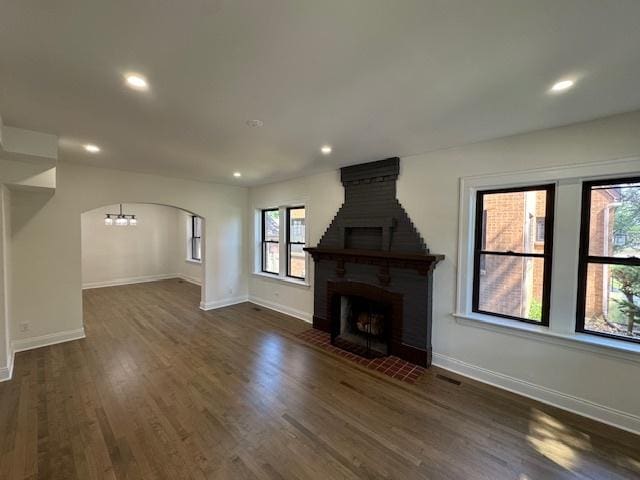 3512 Woodside Ave, Brookfield, IL 60513 - unfurnished living room featuring healthy amount of natural light, dark wood-style floors, recessed lighting, a large fireplace, and arched walkways