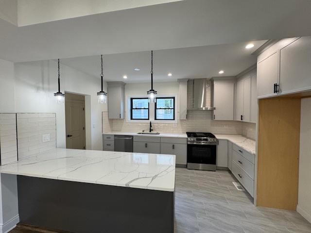 3512 Woodside Ave, Brookfield, IL 60513 - kitchen with stainless steel appliances, wall chimney exhaust hood, a peninsula, light stone counters, and backsplash