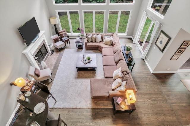 7509 Bittersweet Dr, Gurnee, IL 60031 - living area with a high ceiling, wood finished floors, and a fireplace with flush hearth