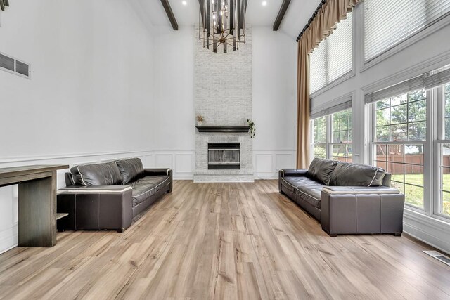2011 Gleneagle Dr, Plainfield, IL 60586 - living room featuring a high ceiling, beamed ceiling, a chandelier, a fireplace, and wood finished floors