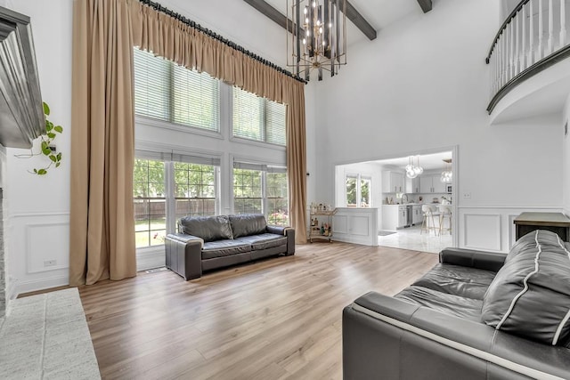 2011 Gleneagle Dr, Plainfield, IL 60586 - living room with a chandelier, a high ceiling, a decorative wall, beamed ceiling, and light wood-style floors