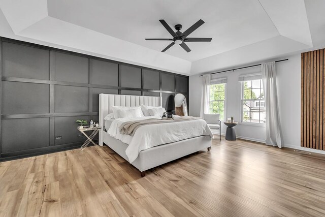 2011 Gleneagle Dr, Plainfield, IL 60586 - bedroom featuring a raised ceiling, a decorative wall, light wood-style floors, and ceiling fan