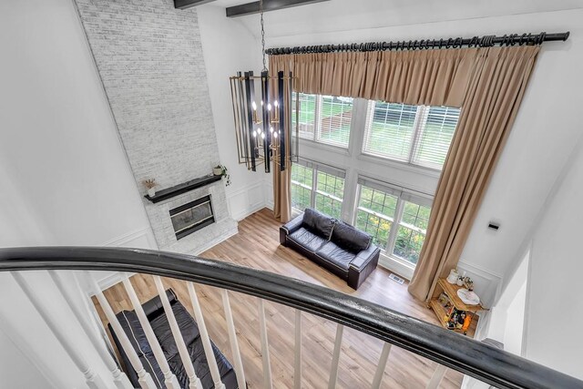 2011 Gleneagle Dr, Plainfield, IL 60586 - stairway with wood finished floors, a fireplace, a chandelier, a decorative wall, and beam ceiling