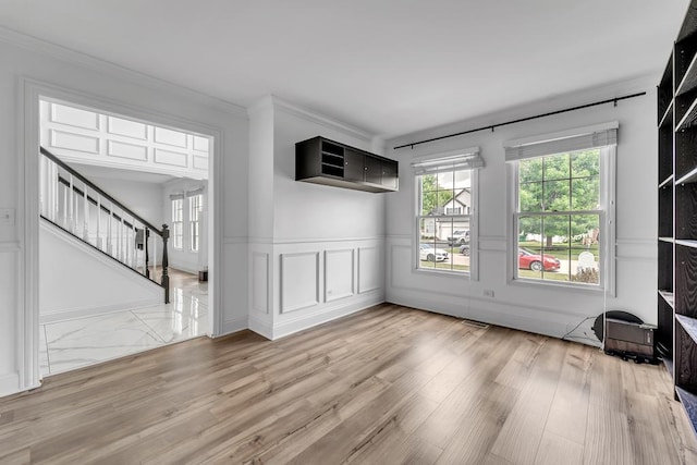 2011 Gleneagle Dr, Plainfield, IL 60586 - unfurnished living room with stairs, a decorative wall, crown molding, wainscoting, and wood finished floors