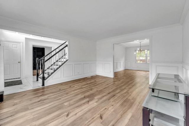 2011 Gleneagle Dr, Plainfield, IL 60586 - unfurnished living room featuring a chandelier, stairway, ornamental molding, a wainscoted wall, and a decorative wall