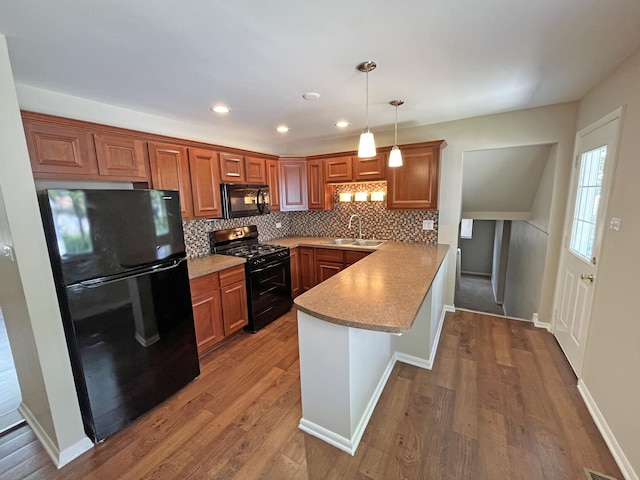 4240 Greenbrier Ln, Richton Park, IL 60471 - kitchen with black appliances, a peninsula, decorative backsplash, brown cabinetry, and wood finished floors