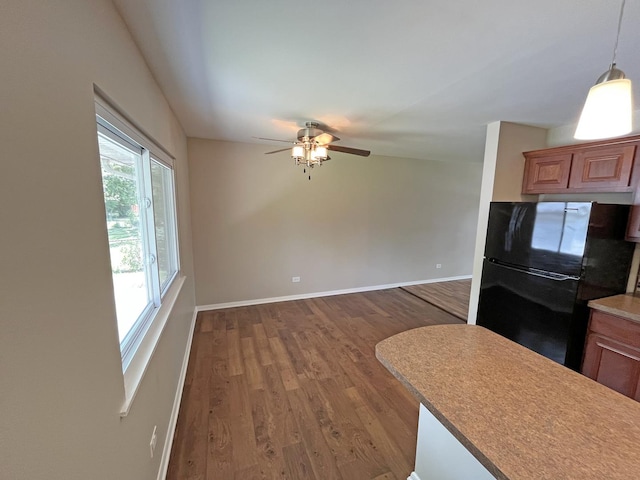 4240 Greenbrier Ln, Richton Park, IL 60471 - kitchen featuring freestanding refrigerator, wood finished floors, ceiling fan, pendant lighting, and brown cabinetry