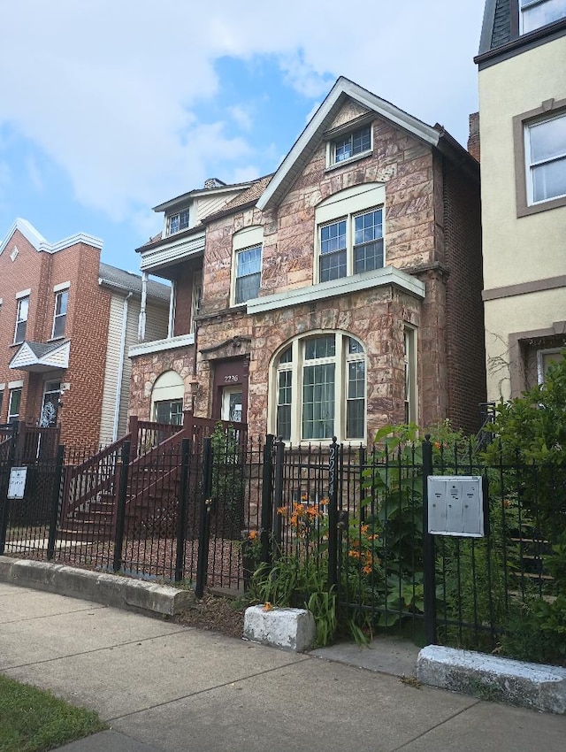 2236 W Monroe St, Chicago, IL 60612 - townhome / multi-family property with stone siding, a fenced front yard, and a gate