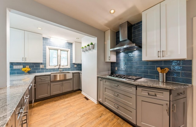536 S Echo Ln, Palatine, IL 60067 - kitchen with wall chimney exhaust hood, stainless steel gas cooktop, light wood finished floors, light stone counters, and decorative backsplash