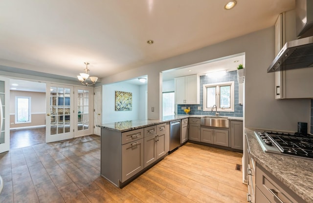 536 S Echo Ln, Palatine, IL 60067 - kitchen with appliances with stainless steel finishes, gray cabinetry, wall chimney range hood, a peninsula, and a chandelier
