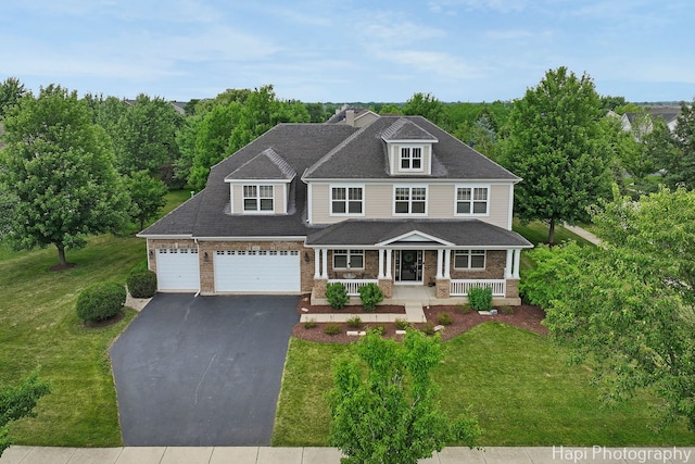 10174 Hopkins St, Huntley, IL 60142 - view of front of house featuring a porch, driveway, a front lawn, and brick siding
