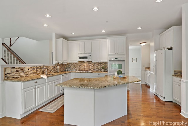 10174 Hopkins St, Huntley, IL 60142 - kitchen featuring white appliances, backsplash, a center island, white cabinets, and recessed lighting