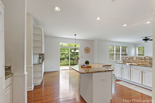 10174 Hopkins St, Huntley, IL 60142 - kitchen featuring a ceiling fan, a kitchen island, white cabinets, light stone countertops, and wood finished floors