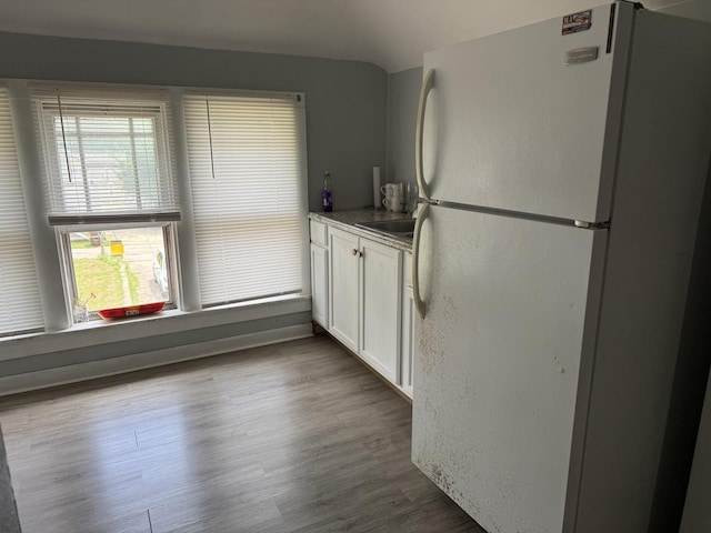 1250 Corbin St, Rockford, IL 61102 - kitchen featuring freestanding refrigerator, white cabinetry, wood finished floors, and lofted ceiling