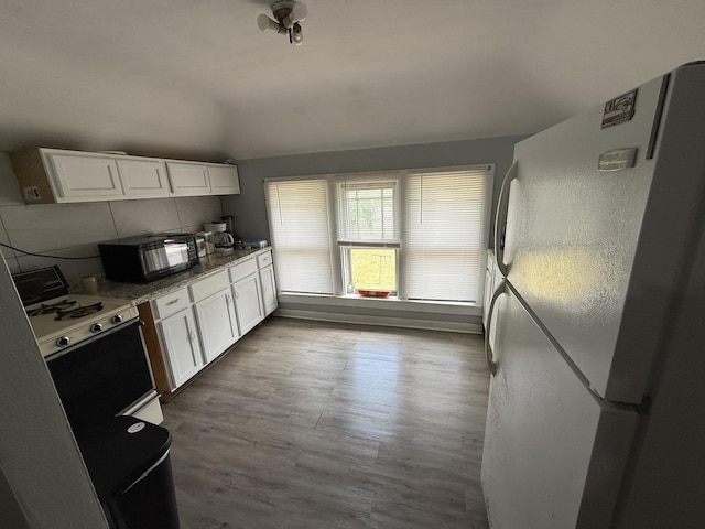 1250 Corbin St, Rockford, IL 61102 - kitchen featuring white appliances, white cabinets, wood finished floors, and ventilation hood