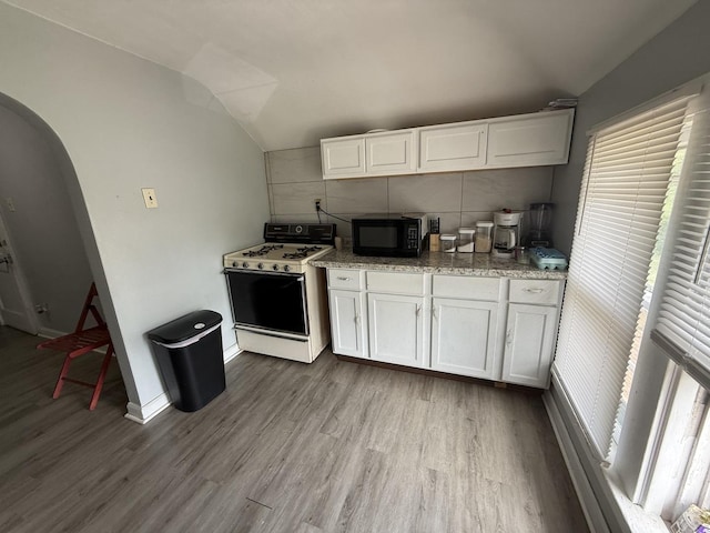 1250 Corbin St, Rockford, IL 61102 - kitchen featuring white range with gas cooktop, black microwave, vaulted ceiling, wood finished floors, and decorative backsplash
