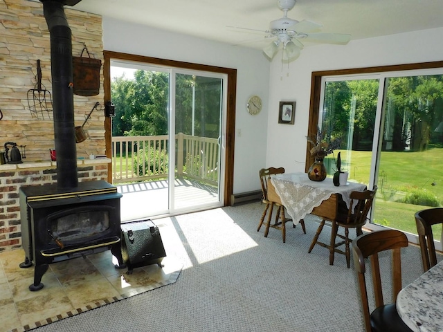 4256 W Egan Rd, Leaf River, IL 61047 - carpeted dining area featuring a wood stove, plenty of natural light, and ceiling fan