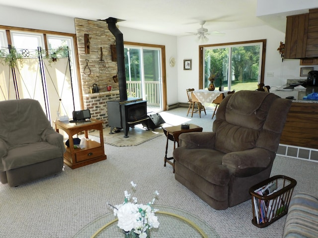 4256 W Egan Rd, Leaf River, IL 61047 - living room with a wood stove, carpet flooring, and a ceiling fan