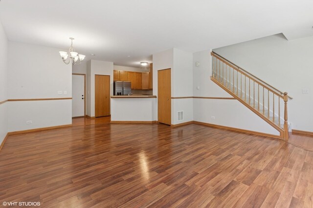 133 Springbrook Trl S, Oswego, IL 60543 - unfurnished living room featuring a chandelier, stairs, and wood finished floors