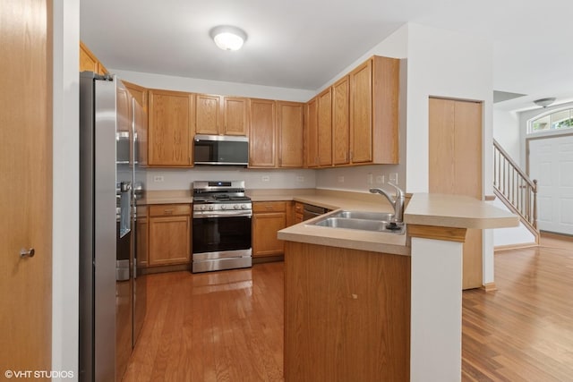 133 Springbrook Trl S, Oswego, IL 60543 - kitchen with stainless steel appliances, a peninsula, light wood finished floors, and light countertops