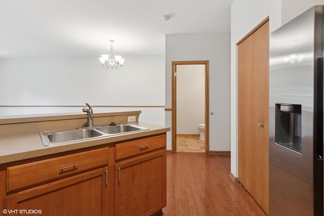 133 Springbrook Trl S, Oswego, IL 60543 - kitchen with stainless steel fridge with ice dispenser, brown cabinets, light wood-style flooring, a chandelier, and light countertops