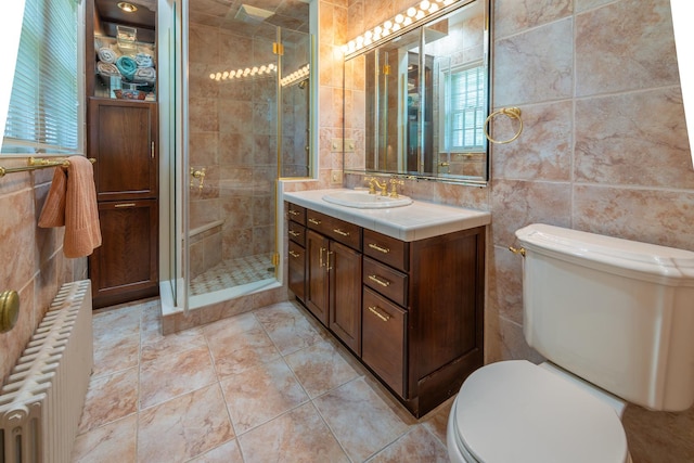 1286 W Stephenson St, Freeport, IL 61032 - bathroom with tile walls, vanity, radiator heating unit, a shower stall, and healthy amount of natural light