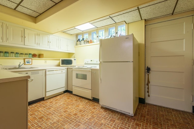 1286 W Stephenson St, Freeport, IL 61032 - kitchen featuring white appliances, a paneled ceiling, light countertops, brick patterned flooring, and white cabinets