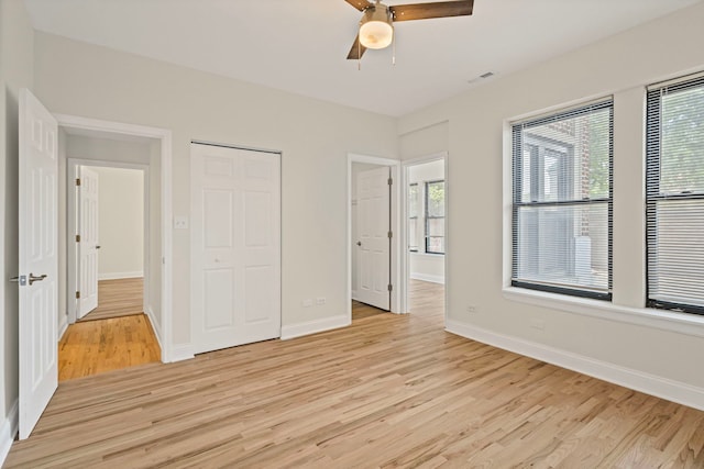4557 S Michigan Ave Unit 1, Chicago, IL 60615 - unfurnished bedroom featuring light wood-style floors, multiple windows, a ceiling fan, and a closet