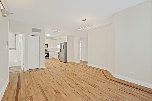 4557 S Michigan Ave Unit 1, Chicago, IL 60615 - unfurnished living room with light wood-style flooring and baseboards