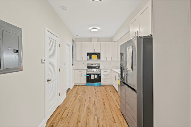 4557 S Michigan Ave Unit 1, Chicago, IL 60615 - kitchen featuring appliances with stainless steel finishes, electric panel, light wood-style floors, and white cabinets