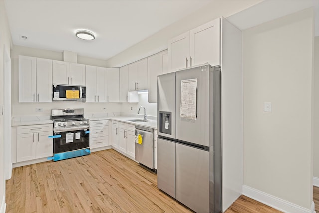 4557 S Michigan Ave Unit 1, Chicago, IL 60615 - kitchen featuring appliances with stainless steel finishes, light wood-type flooring, light countertops, and white cabinetry