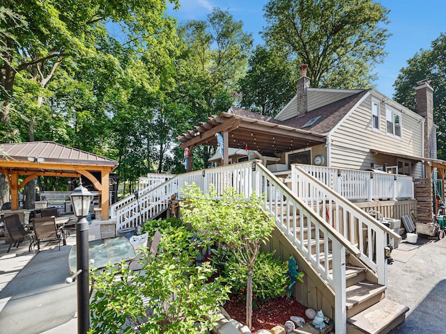 385 E Irving Park Rd, Streamwood, IL 60107 - view of side of home featuring stairway, a gazebo, and a chimney