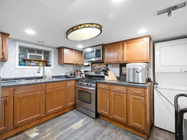 385 E Irving Park Rd, Streamwood, IL 60107 - kitchen featuring stainless steel appliances, stacked washer / dryer, dark countertops, tasteful backsplash, and recessed lighting
