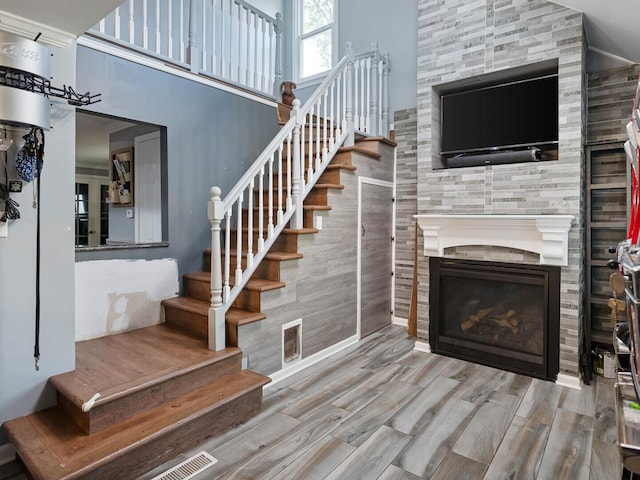 385 E Irving Park Rd, Streamwood, IL 60107 - stairs featuring wood finished floors, a fireplace, and a high ceiling