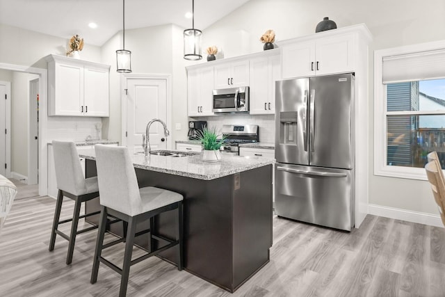 2621 Shale Rd, Normal, IL 61761 - kitchen featuring stainless steel appliances, backsplash, light wood-style floors, white cabinets, and a breakfast bar