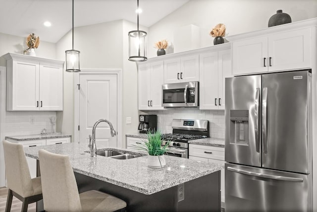 2621 Shale Rd, Normal, IL 61761 - kitchen with stainless steel appliances, a kitchen breakfast bar, white cabinetry, tasteful backsplash, and an island with sink