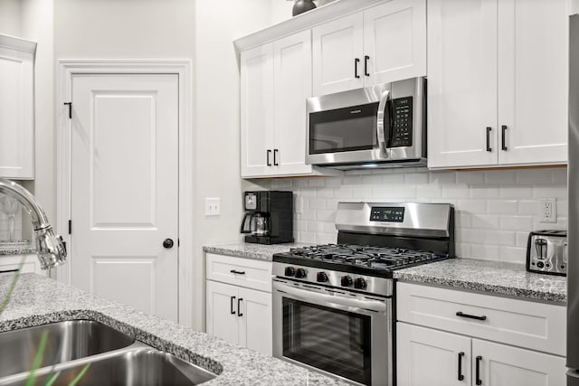 2621 Shale Rd, Normal, IL 61761 - kitchen featuring stainless steel appliances, backsplash, white cabinets, and light stone countertops