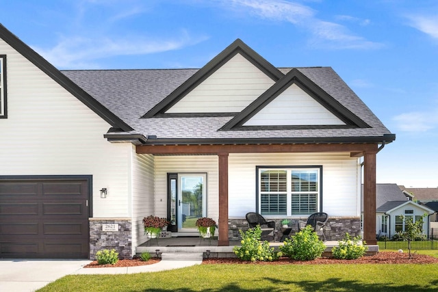 2621 Shale Rd, Normal, IL 61761 - view of front of home with covered porch, a shingled roof, stone siding, and an attached garage