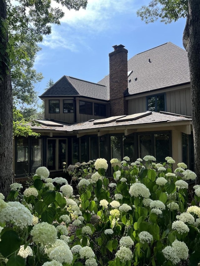 16612 S Catawba Rd, Homer Glen, IL 60491 - back of house with board and batten siding, a sunroom, a chimney, and a shingled roof