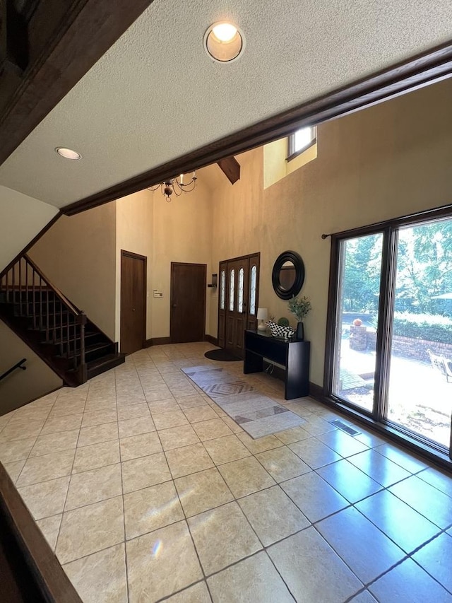 16612 S Catawba Rd, Homer Glen, IL 60491 - tiled entrance foyer featuring a textured ceiling, a high ceiling, stairs, and a chandelier