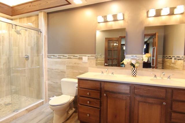 16612 S Catawba Rd, Homer Glen, IL 60491 - full bathroom featuring tile walls, double vanity, a shower stall, a wainscoted wall, and wood finished floors