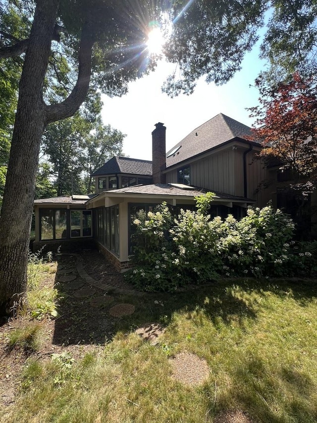 16612 S Catawba Rd, Homer Glen, IL 60491 - back of house with a sunroom, a chimney, roof with shingles, and a yard
