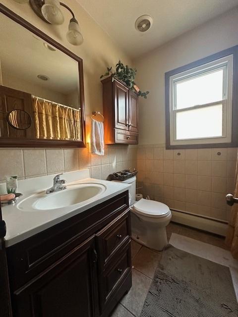 4540 N Menard Ave, Chicago, IL 60630 - bathroom featuring tile walls, a baseboard heating unit, tile patterned floors, vanity, and wainscoting