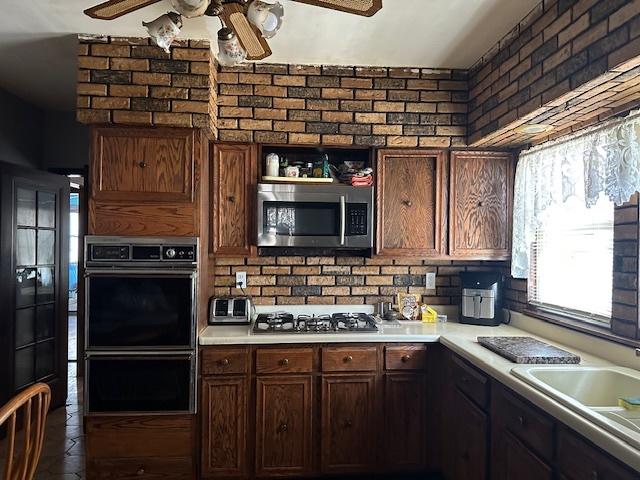 4540 N Menard Ave, Chicago, IL 60630 - kitchen with appliances with stainless steel finishes, ceiling fan, light countertops, and open shelves