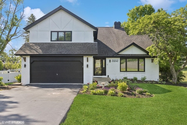 9N909 Koshare Trl, Elgin, IL 60124 - view of front of house with a shingled roof, brick siding, driveway, an attached garage, and a chimney