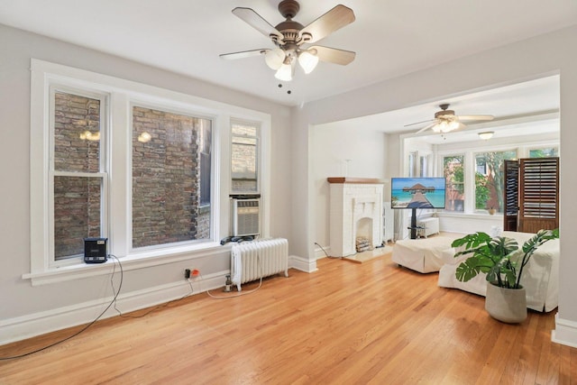 4702 N Campbell Ave Unit 2, Chicago, IL 60625 - living room with a brick fireplace, radiator, ceiling fan, and wood finished floors