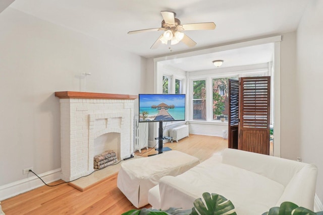 4702 N Campbell Ave Unit 2, Chicago, IL 60625 - living area with wood finished floors, radiator heating unit, a ceiling fan, and a fireplace