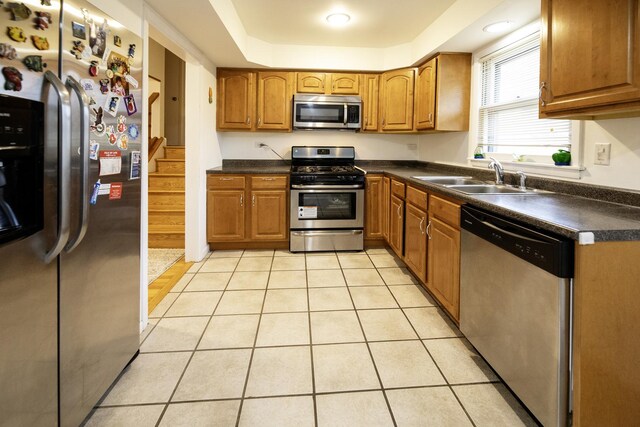 1065 Irwin Ave, Des Plaines, IL 60018 - kitchen with stainless steel appliances, brown cabinetry, dark countertops, and light tile patterned flooring